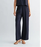 Woman wearing a navy wide-leg pants on a light gray background