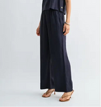 Woman wearing navy wide-leg pants on a light gray background