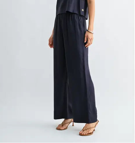 Woman wearing navy wide-leg pants on a light gray background