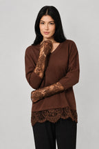 Woman wearing a small ribbed brown shirt with lace sleeves and hem against a white drape background