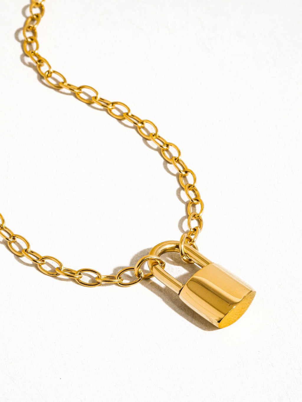 Gold lock necklace on a white background