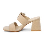 Sand color sandal with a block heel and double strap with statement buckle on a white background