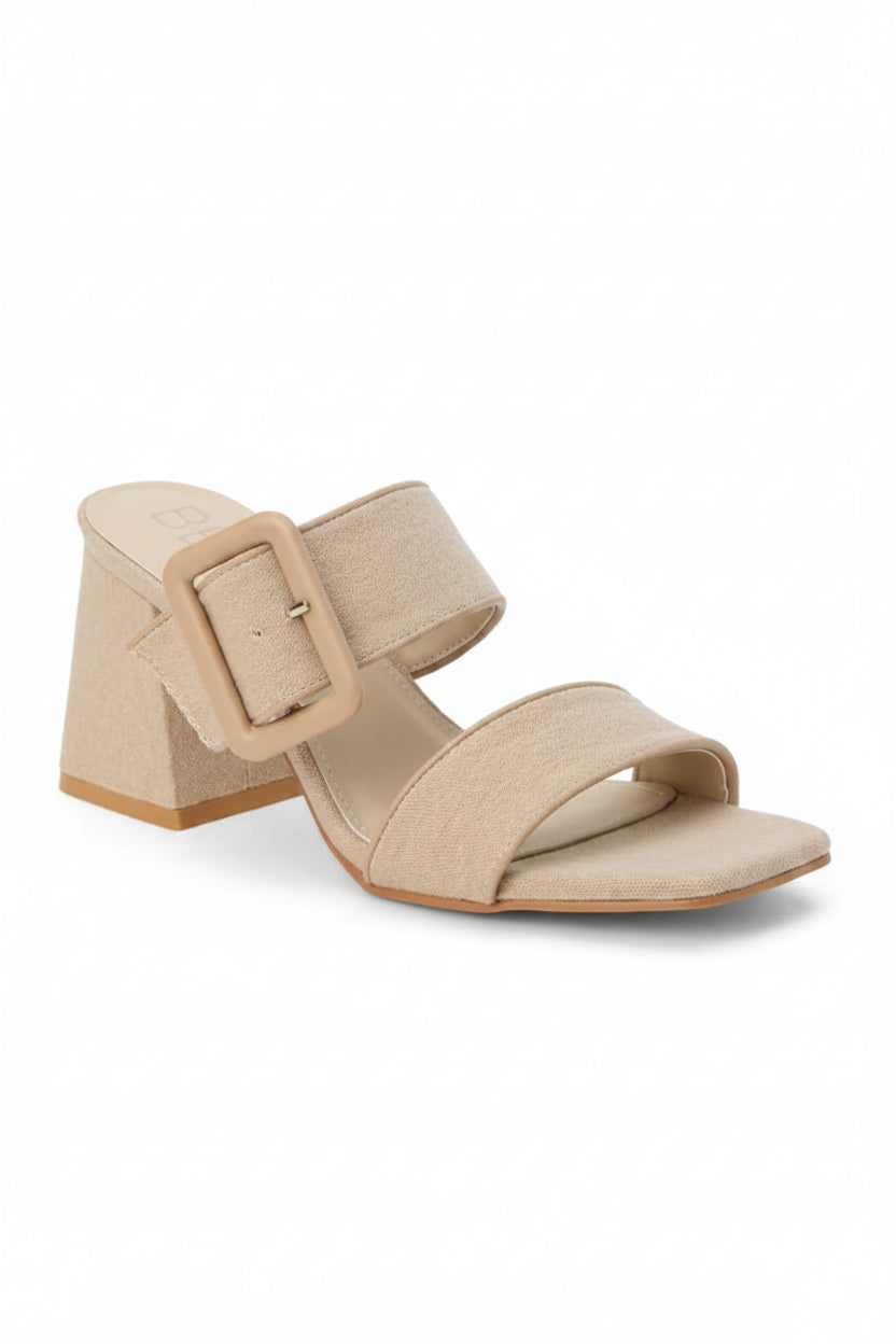 Sand color sandal with a block heel and double strap with statement buckle on a white background