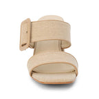 Sand color sandal with a block heel and double strap with statement buckle on a white background