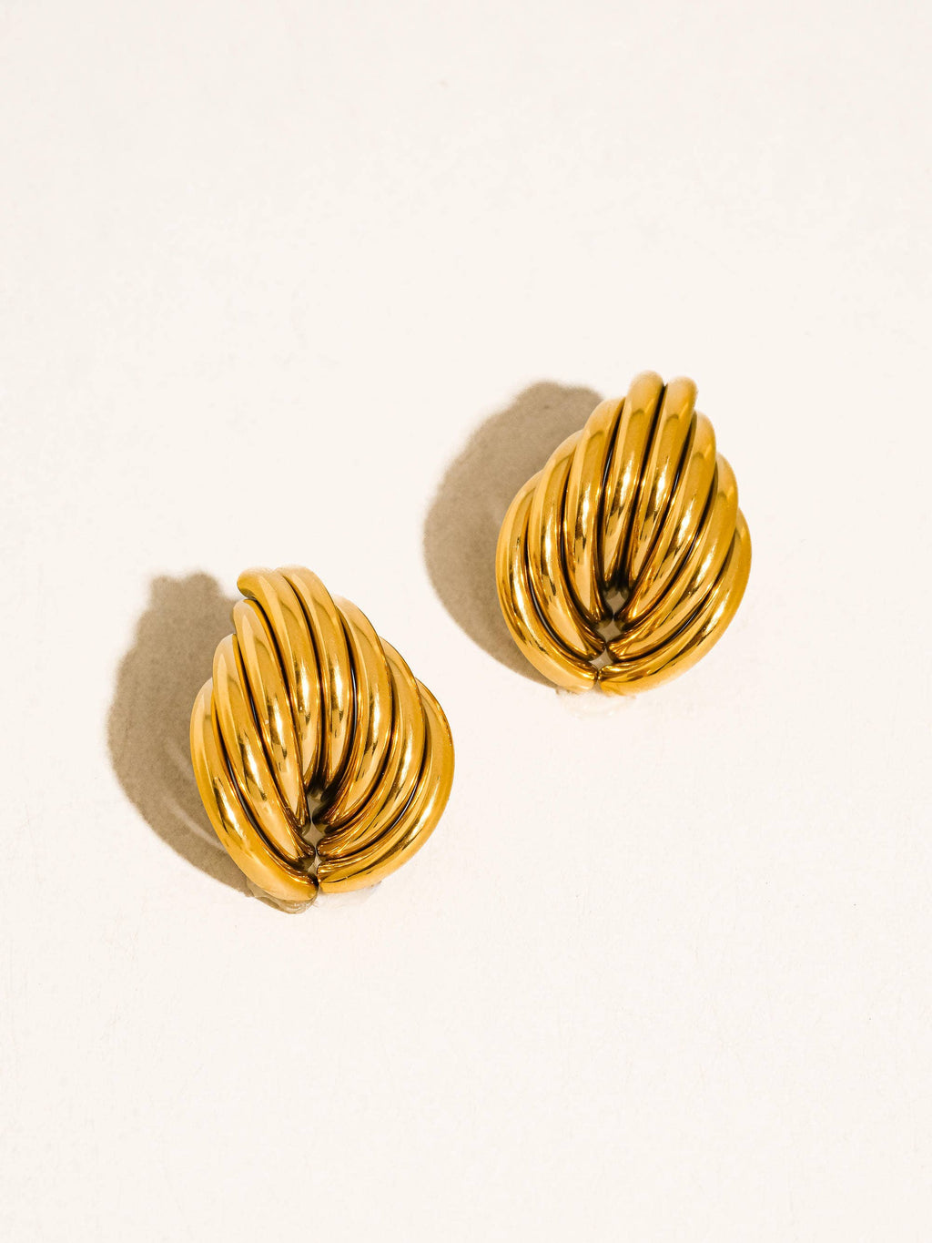 Pair of gold tone layered post earrings on a white background