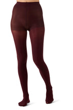 A view of a person's legs wearing opaque wine tights against a plain white background.