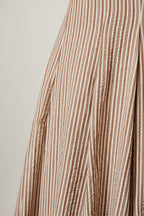 A close-up of a vertically striped fabric with alternating thin brown and off-white stripes, showing a soft seersucker texture.