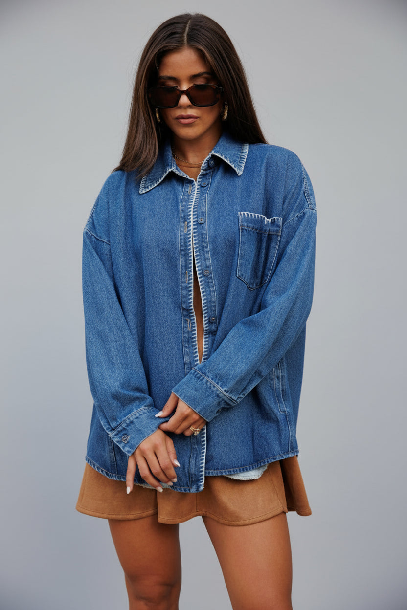 Woman wearing a blue denim shacket with contrast stitching over a brown dress.