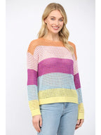 Woman wearing an open weave color block striped sweater on a white background