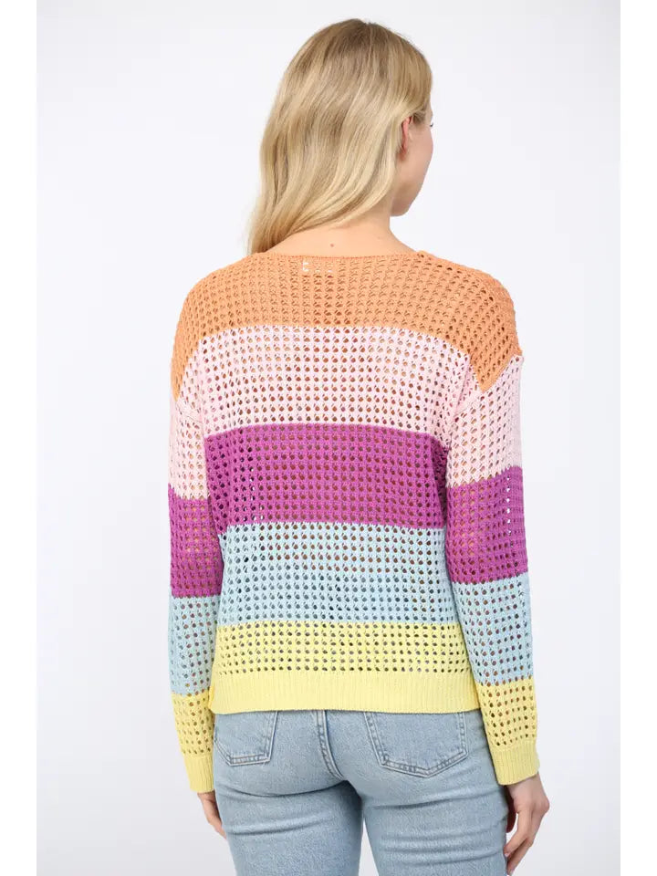 Back view of a woman wearing an open weave color block striped sweater on a white background
