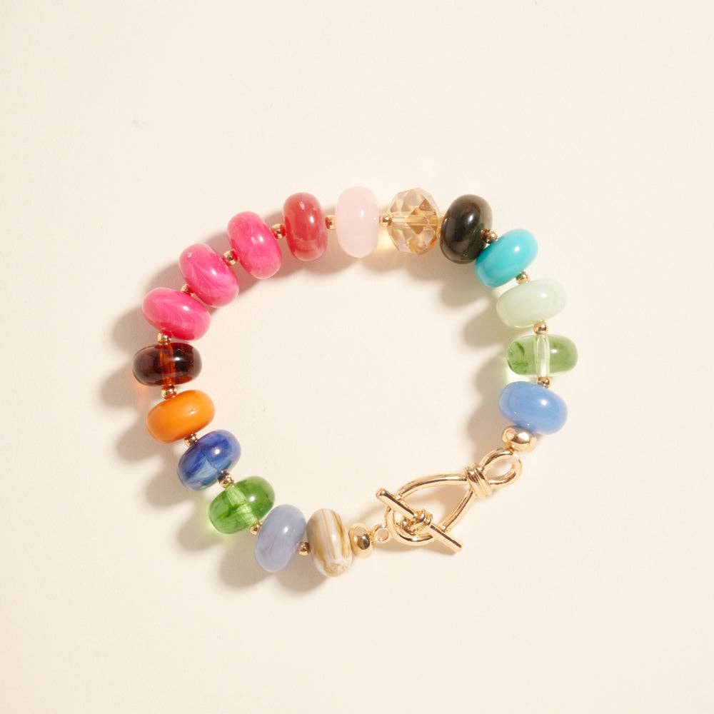 Colorful beaded bracelet with a gold bar toggle clasp on a light background