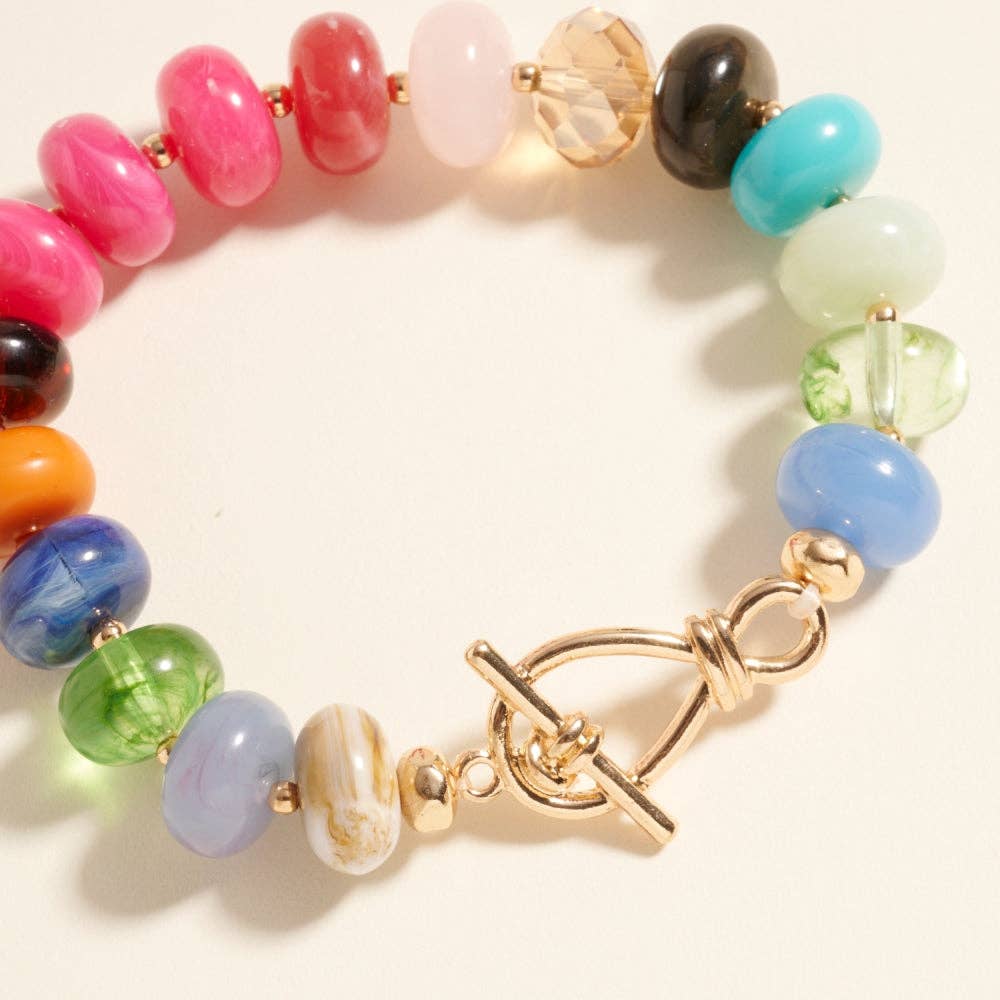 Colorful beaded bracelet with a gold bar toggle clasp on a light background