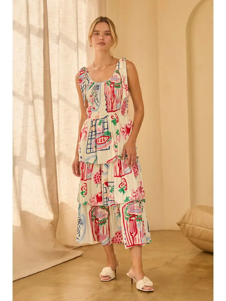 Woman wearing a shoulder tie colorfut print dress with abstract patterns in a softly lit room