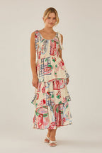 Woman wearing a shoulder tie colorfut print dress with abstract patterns in a softly lit room