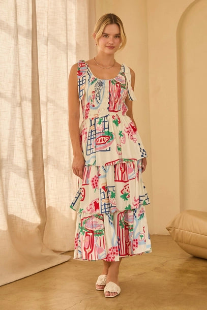 Woman wearing a shoulder tie colorfut print dress with abstract patterns in a softly lit room
