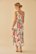Back view of a woman wearing a shoulder tie colorfut print dress with abstract patterns in a softly lit room