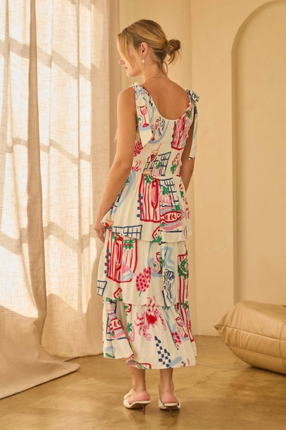 Back view of a woman wearing a shoulder tie colorfut print dress with abstract patterns in a softly lit room