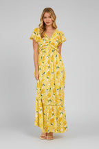 Woman wearing a yellow lemon print dress in a living room setting