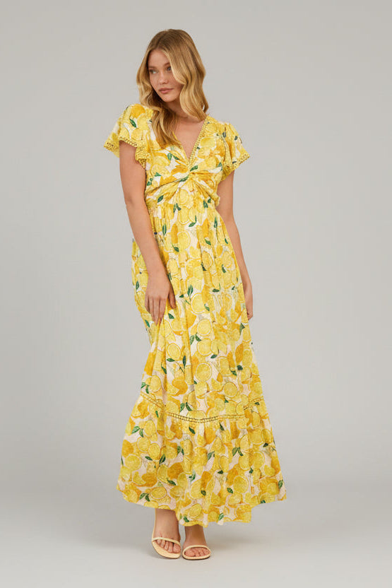 Woman wearing a yellow lemon print dress in a living room setting