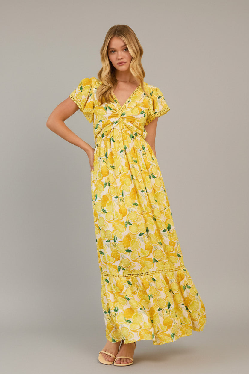 Woman wearing a yellow lemon print dress in a living room setting