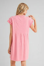 Back  view of a woman wearing pink solid knit knee length dress with dart detailing on beige background