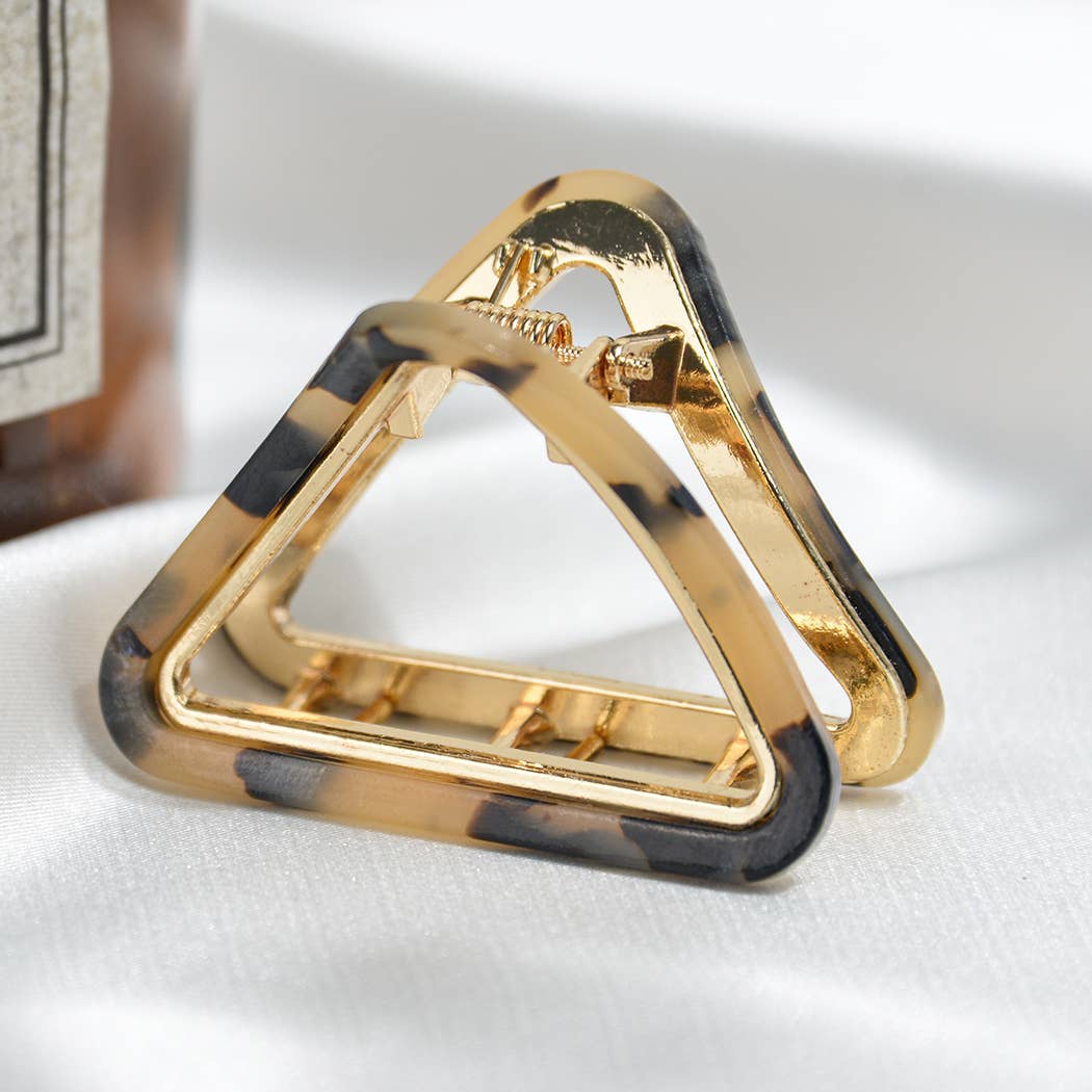 Gold and tortoiseshell triangle-shaped hair clip on a white background