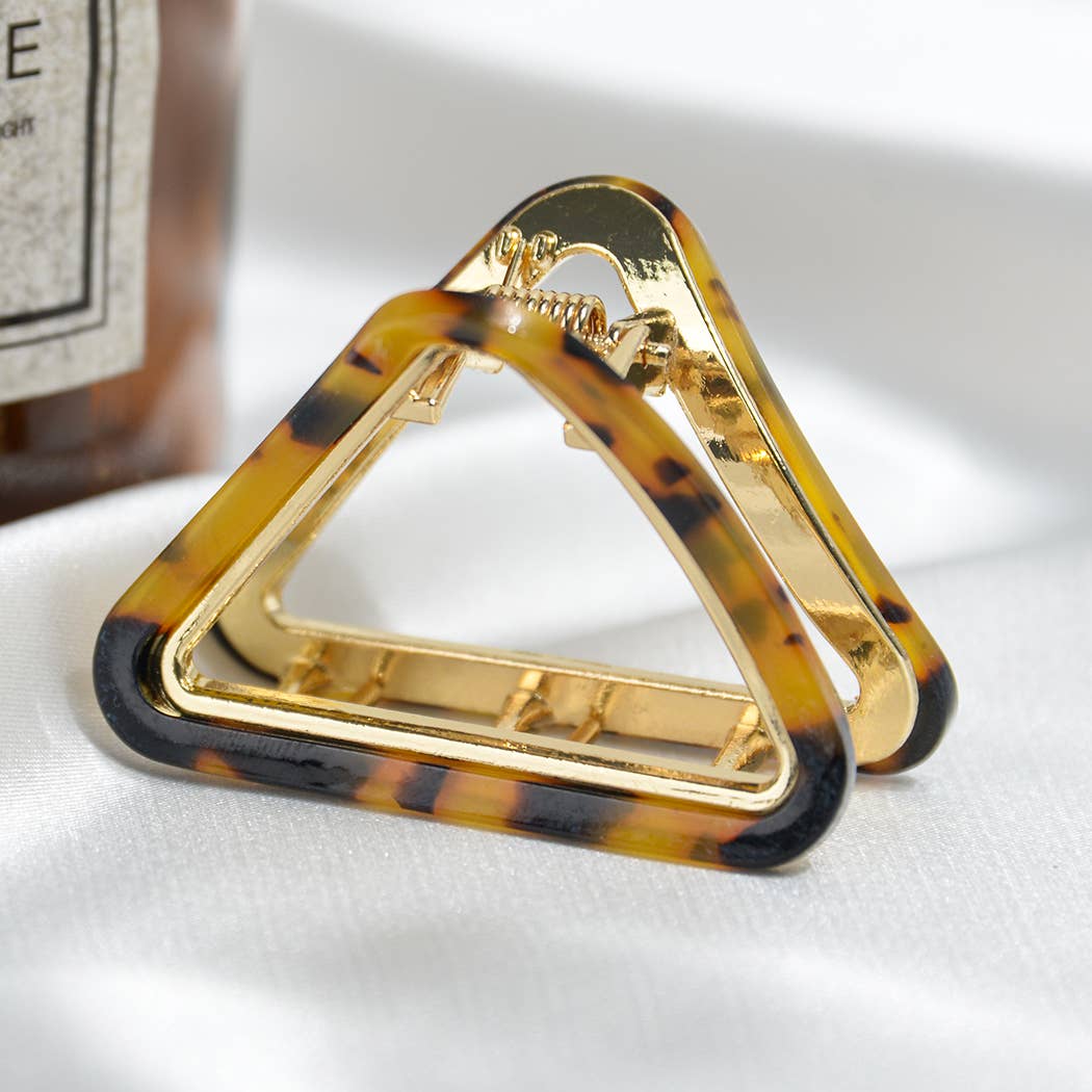 Triangular hair clip with tortoiseshell and gold accents on a white background