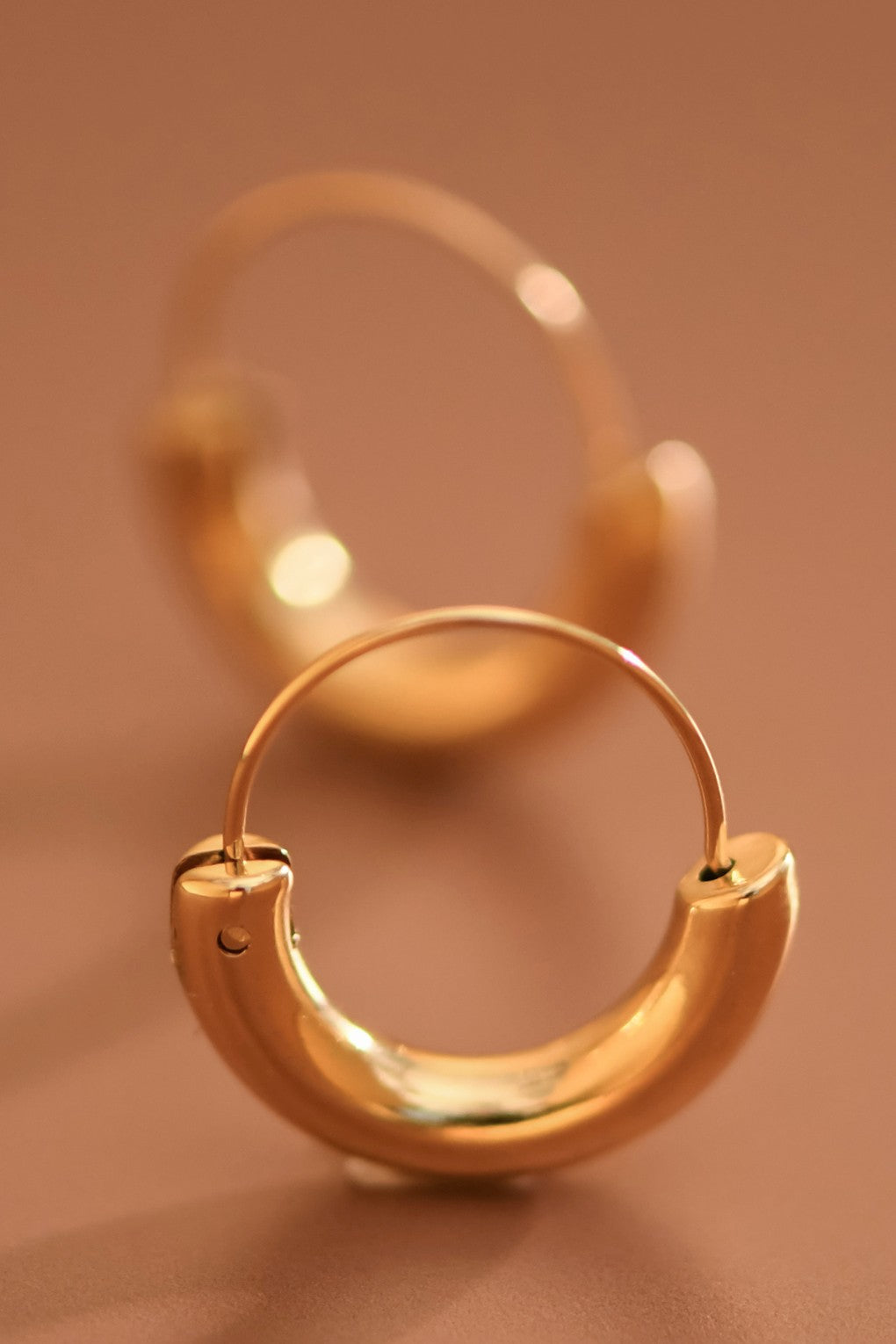 18k gold-plated stainless steel chunky hoop earrings on a brown background