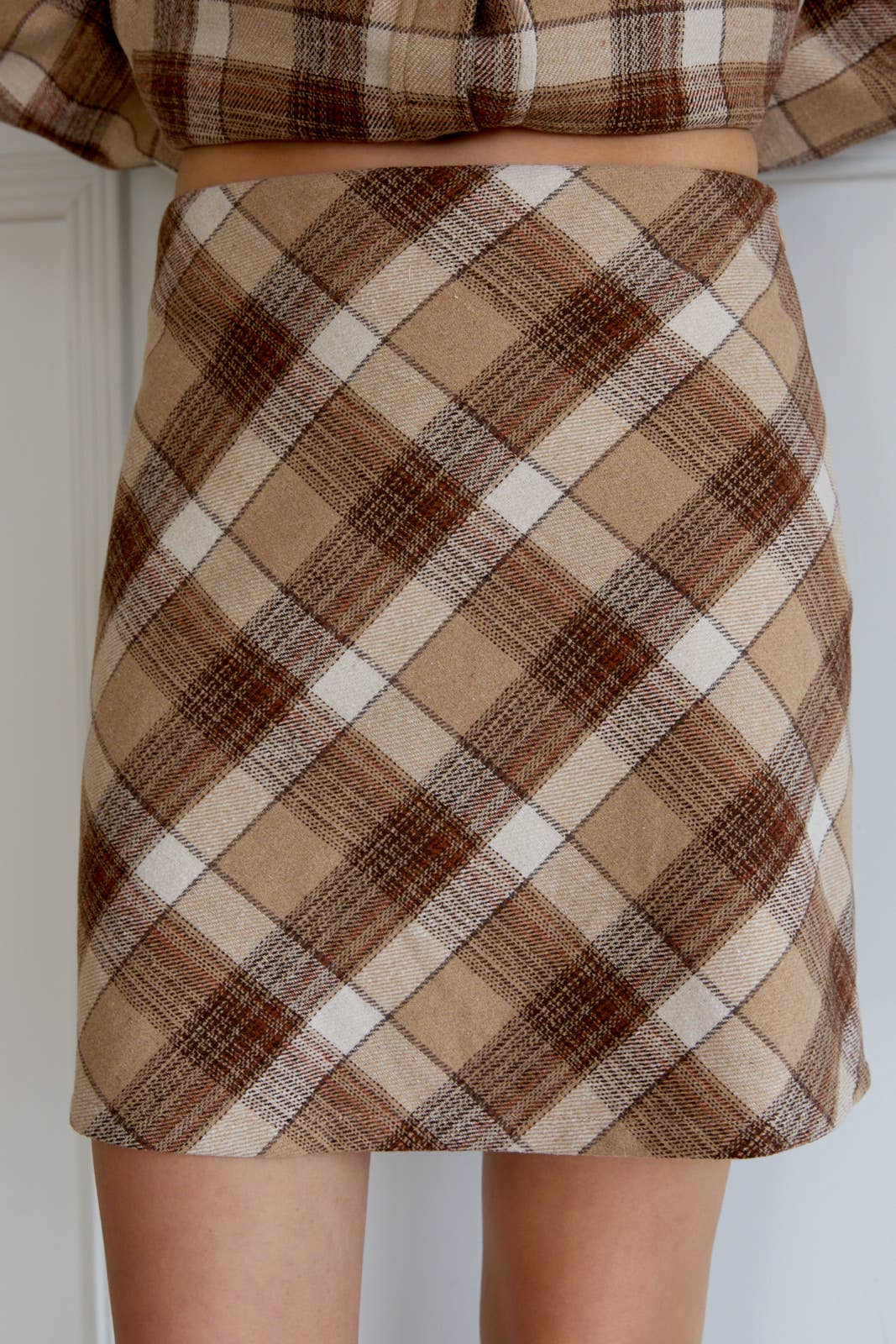Plaid skirt with brown and beige pattern on a plain background