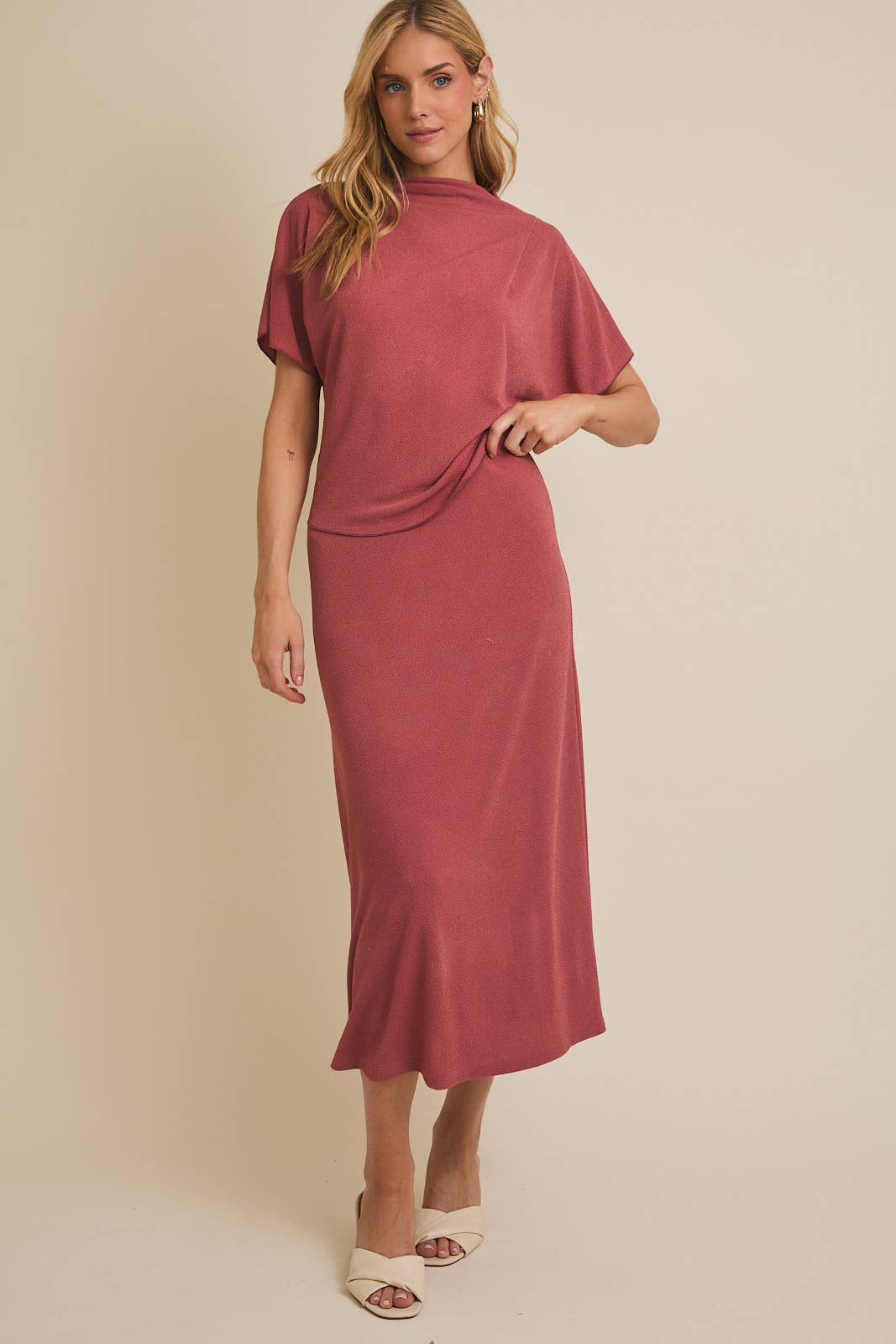 Woman wearing a mauve skirt on a beige background