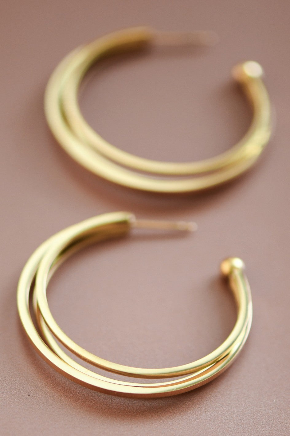 18k gold-plated stainless steel triple hoop earrings on a brown background