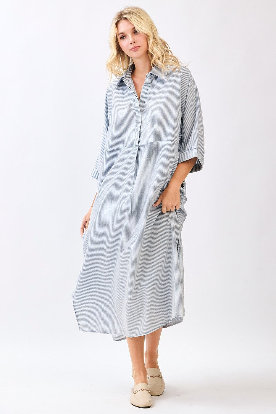 Woman wearing a striped blue dress on a white background