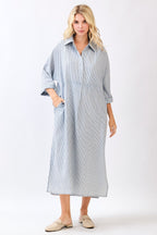Woman wearing a striped blue dress with a white background