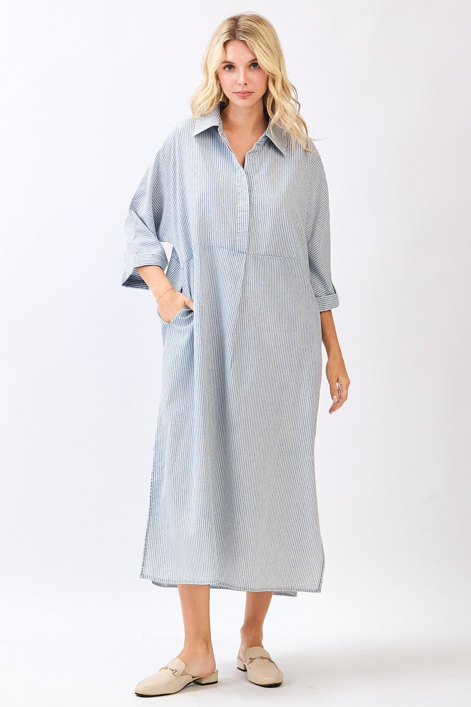 Woman wearing a striped blue dress with a white background