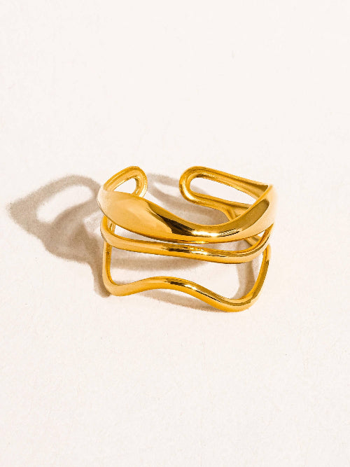 Gold tone geometric abstract ring against a white background