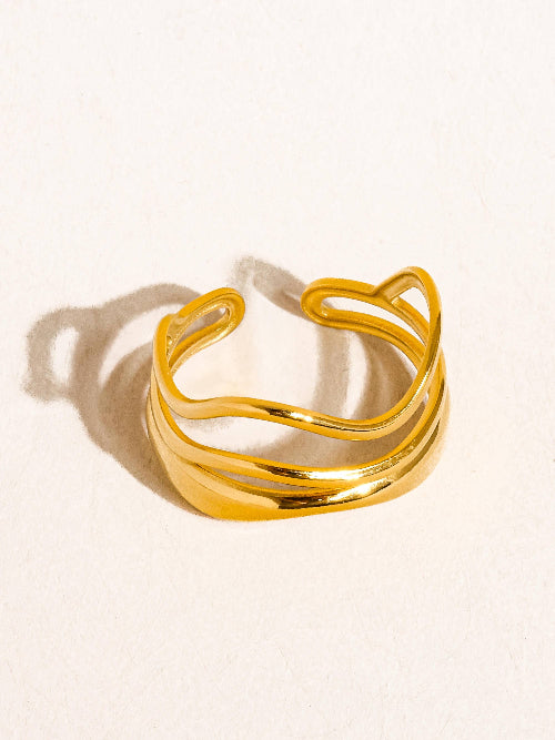 Gold tone geometric abstract ring against a white background