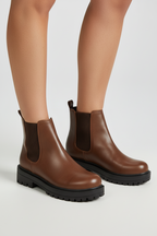 Brown leather ankle boot with a black rugged sole