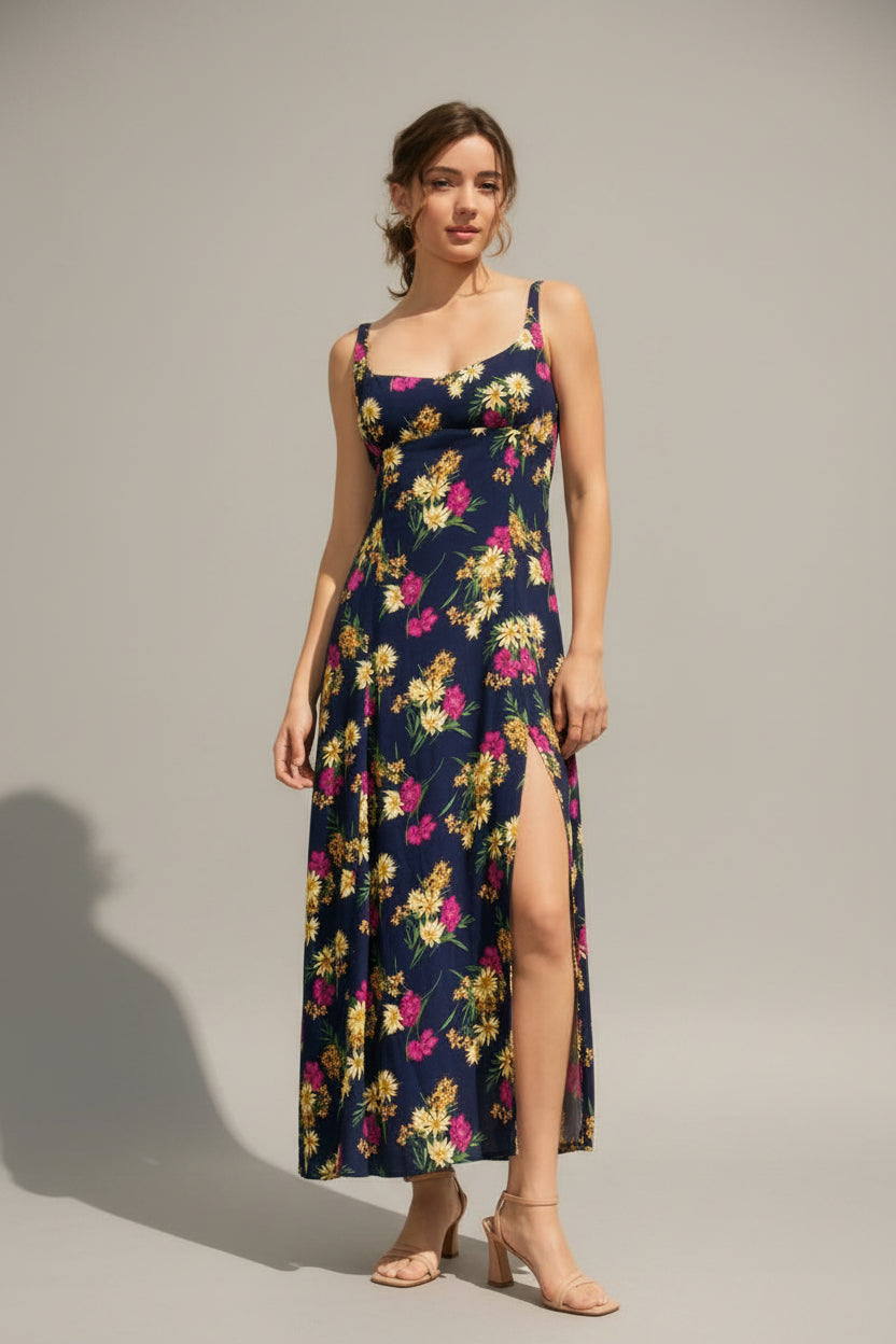 Woman wearing a navy floral dress with side slit against a light background