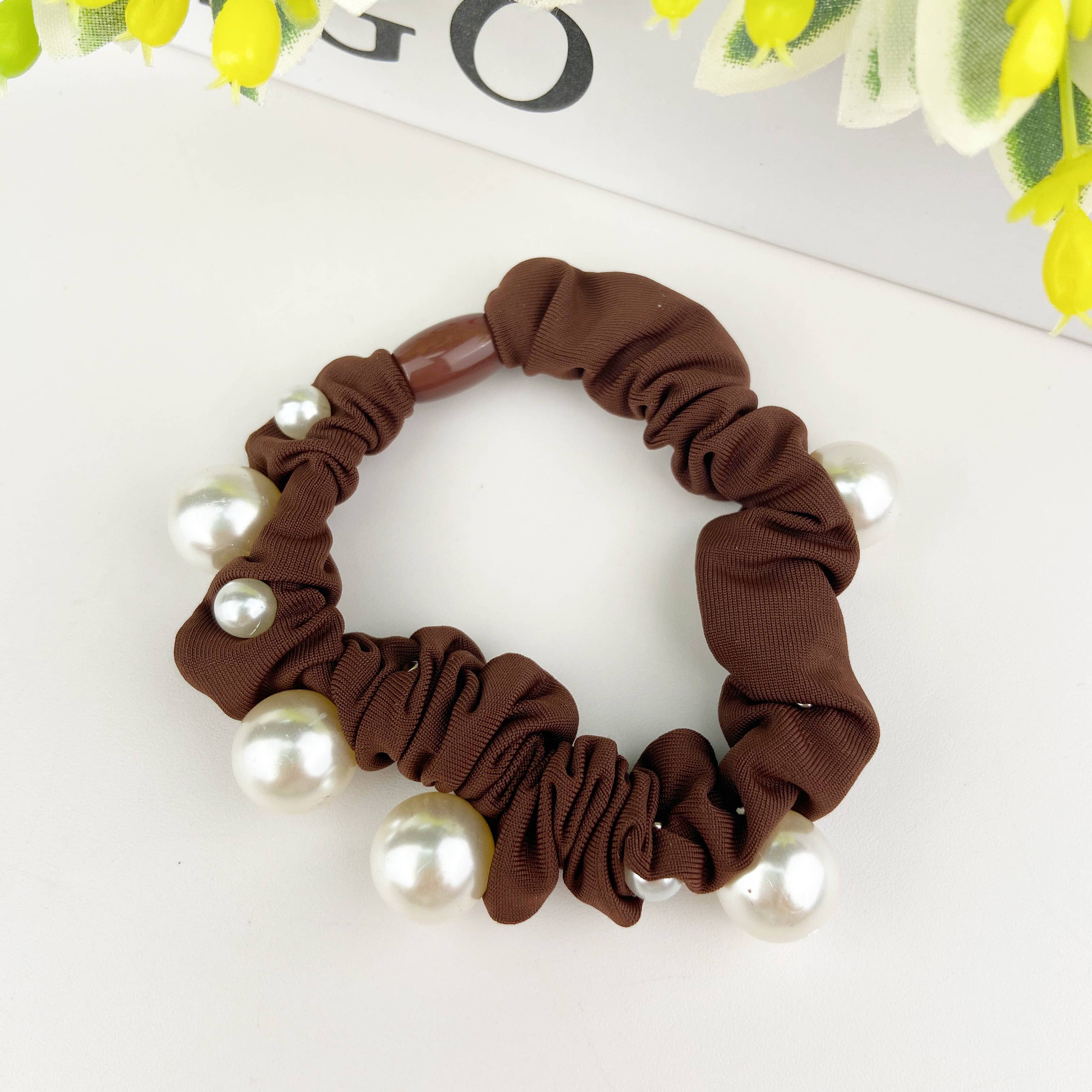 Brown scrunchie with pearls on a white background