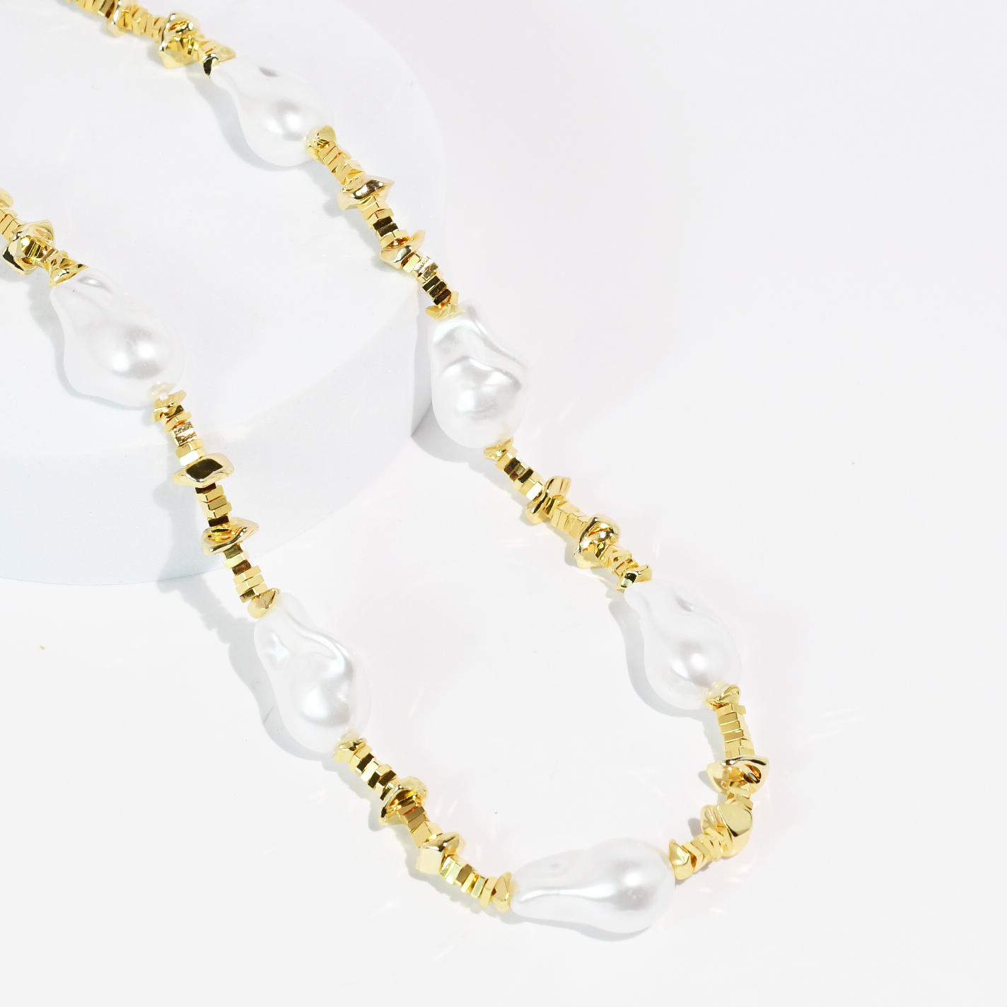 Necklace with white pearls and gold beads on a white background