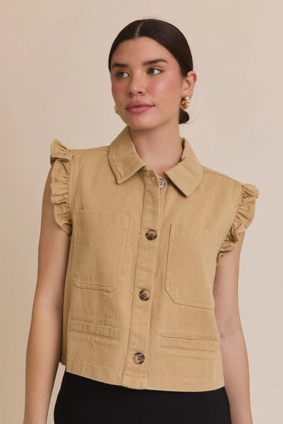 Woman wearing taupe ruffle detail button down collar jean vest on beige  background