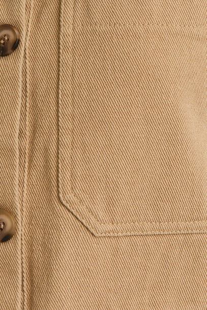 Close up of taupe ruffle detail button down collar jean vest