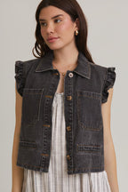Woman wearing ruffle sleeve detail charcoal vest on striped dress on beige background
