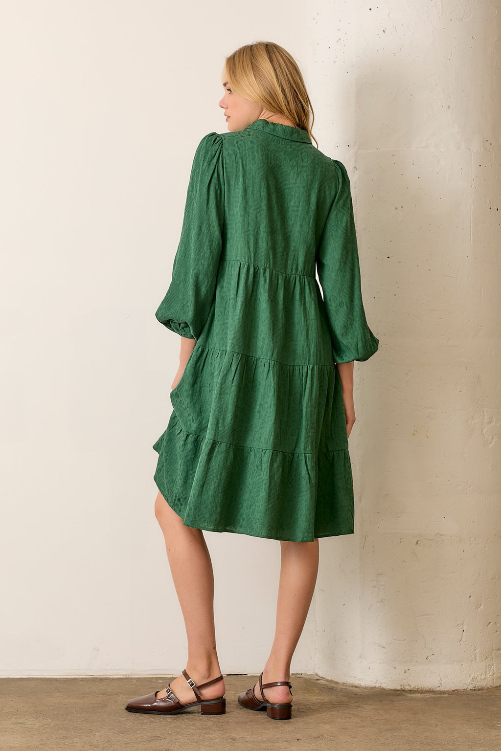 Woman wearing hunter green button front long sleeve midi dress on white background