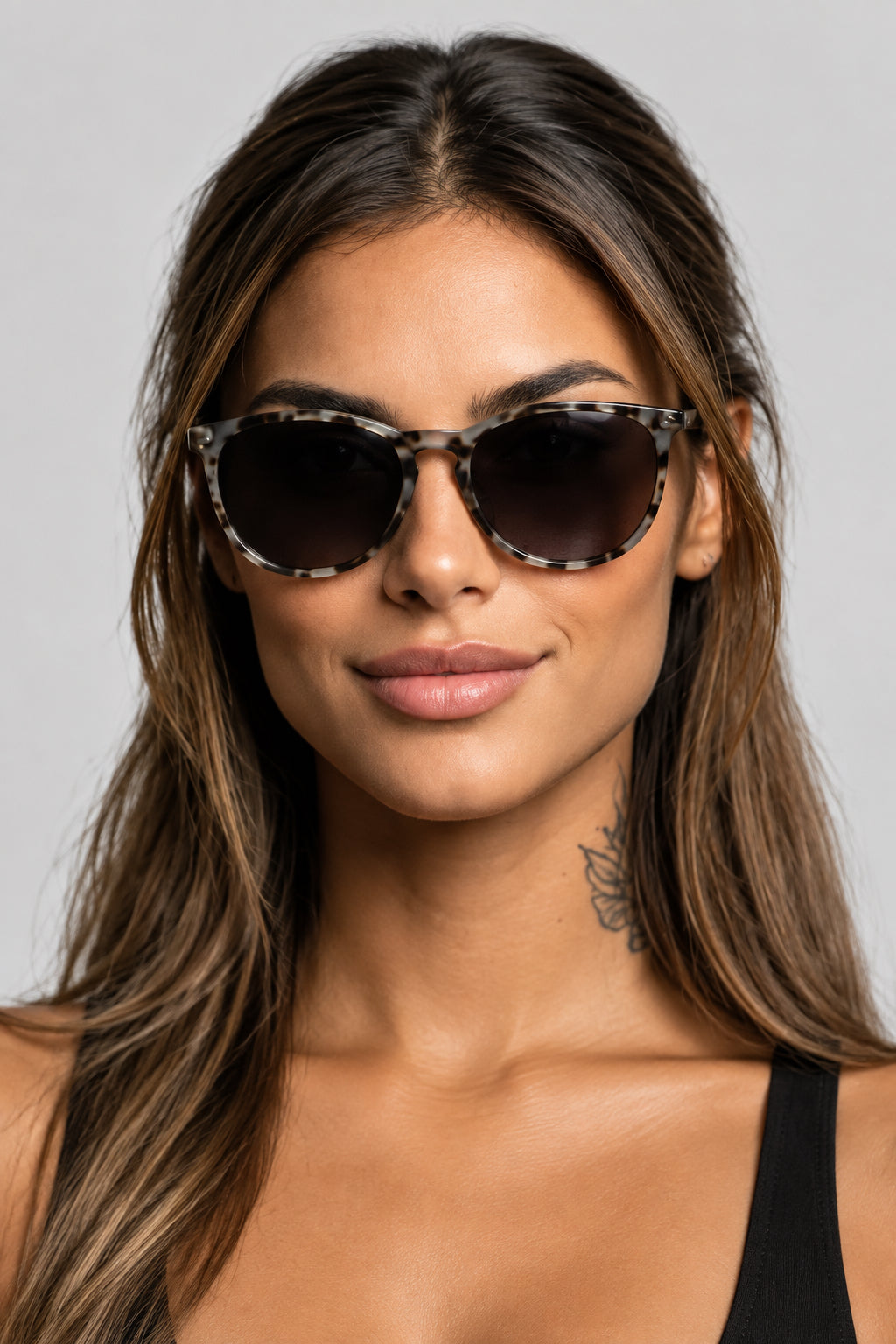 Woman wearing ash cheetah frame sunglasses against a white background