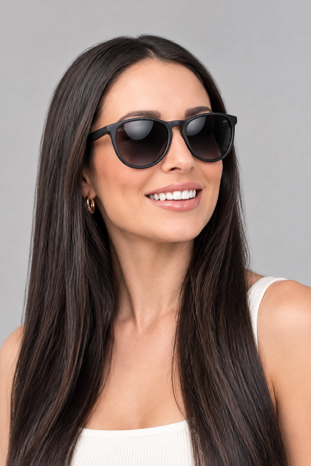 Woman wearing black sunglasses with sitting on a blue chair outdoors