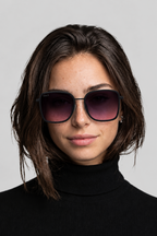 Woman wearing Smokeshow sunglasses with a plain background