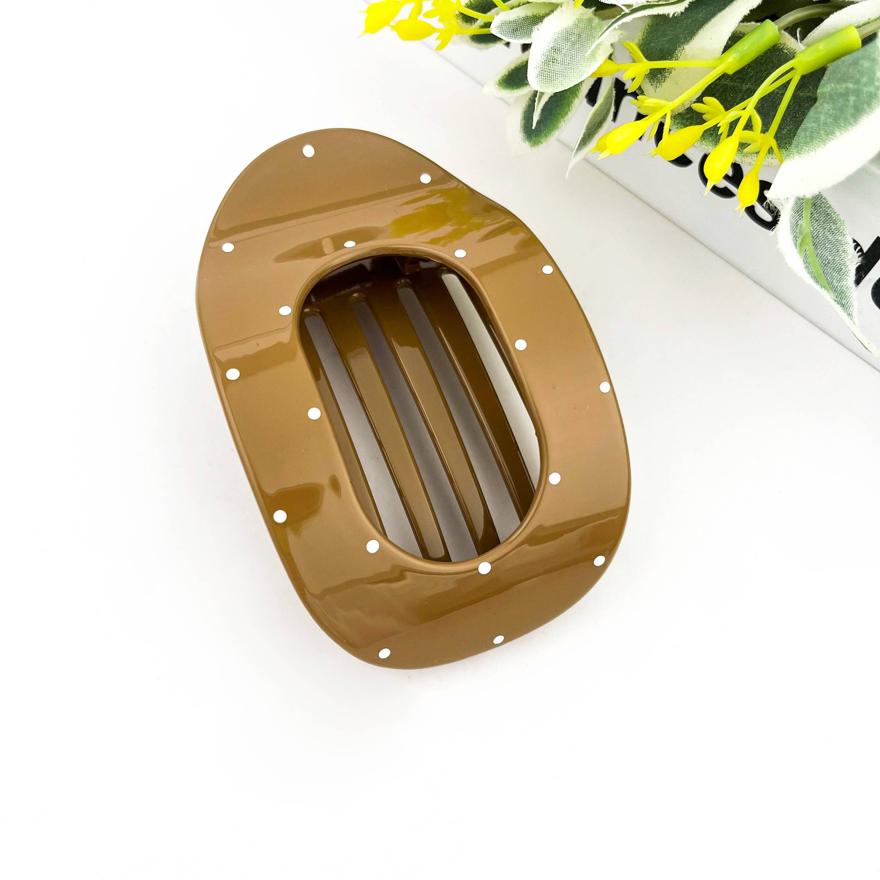 Light brown polka dot flat hair clip on a white background