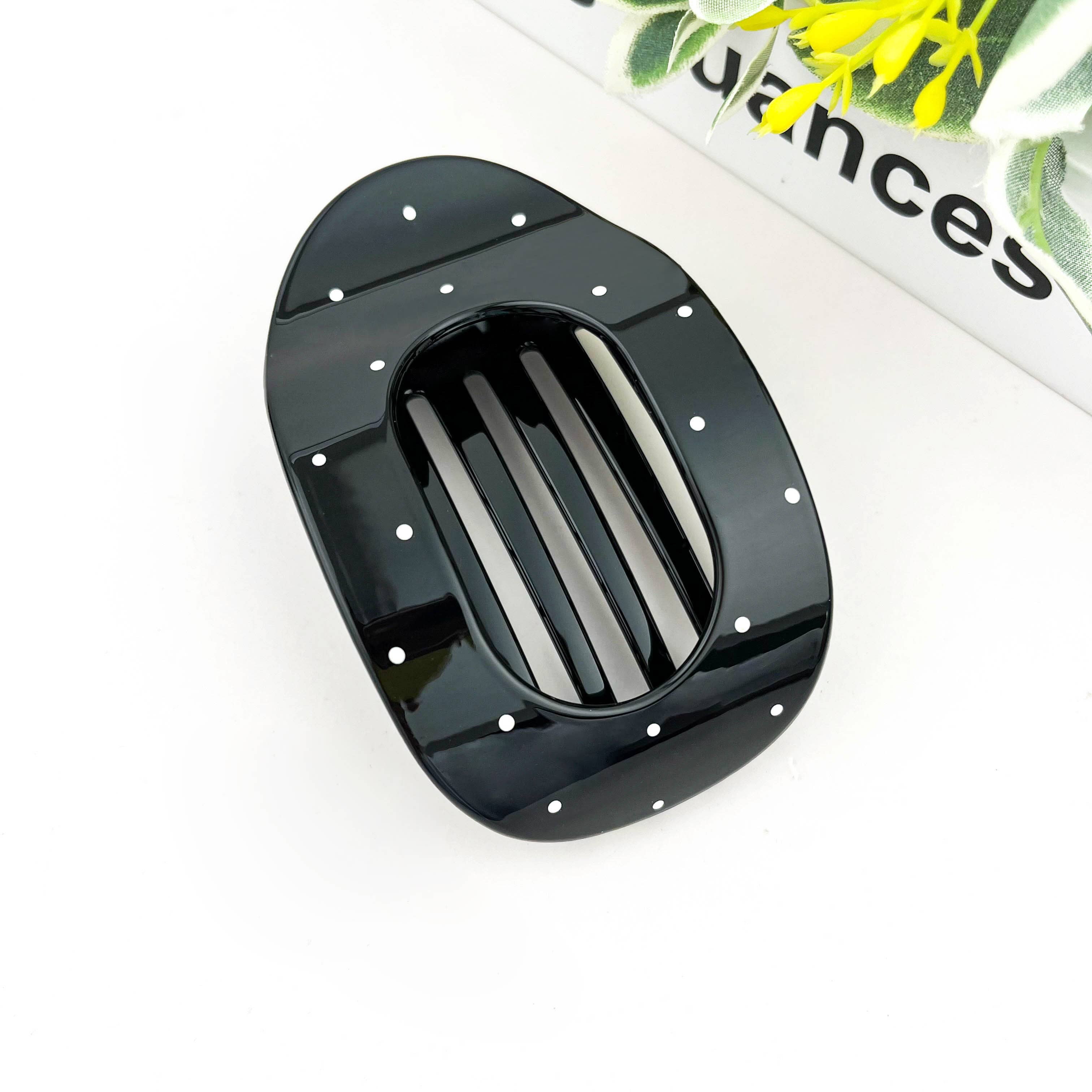 Black polka dot flat hair clip on white background