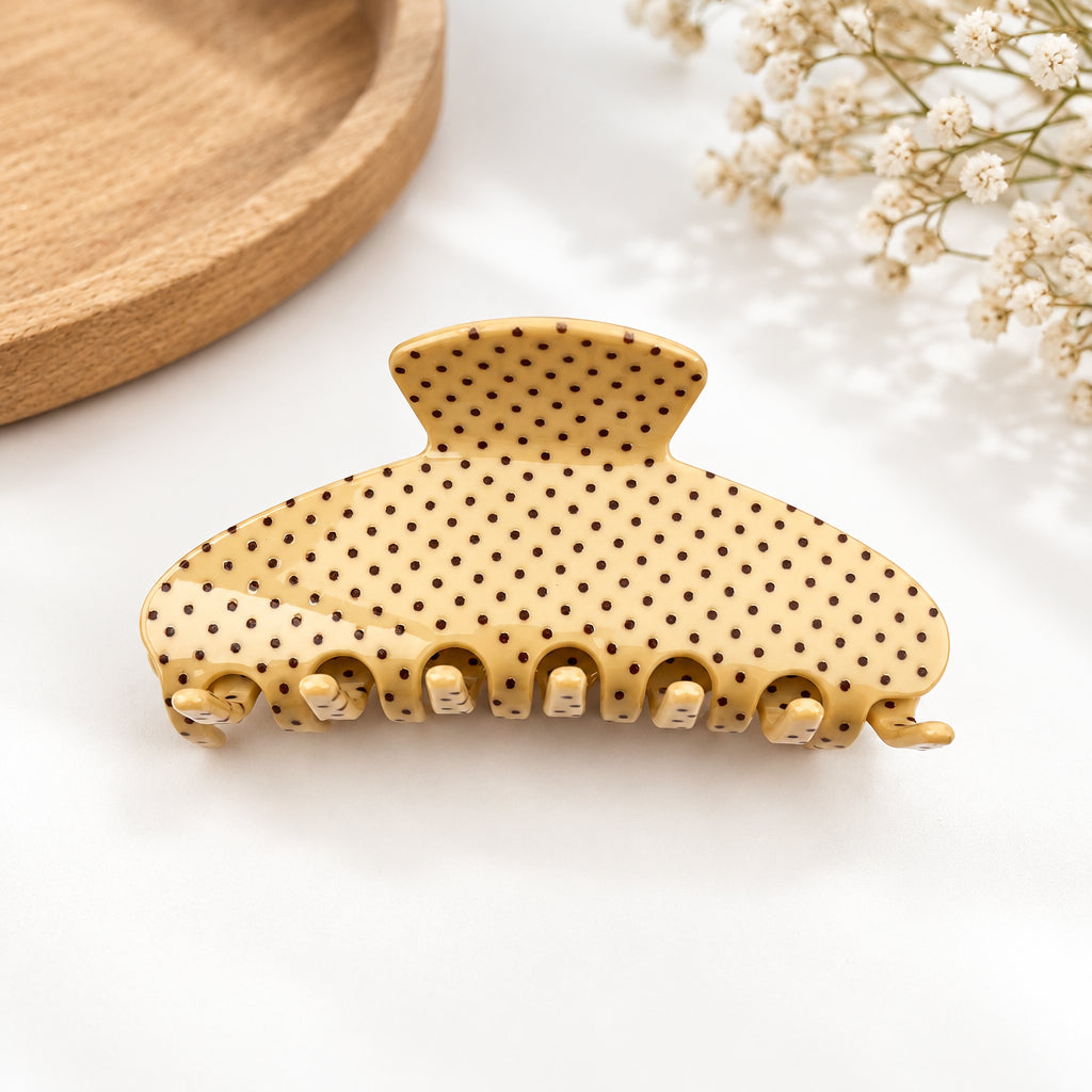 Beige hair claw with brown polka dots on a white background 